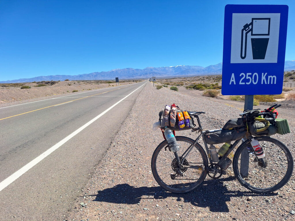 fully loaded bicycle on side of a road running to the mountains