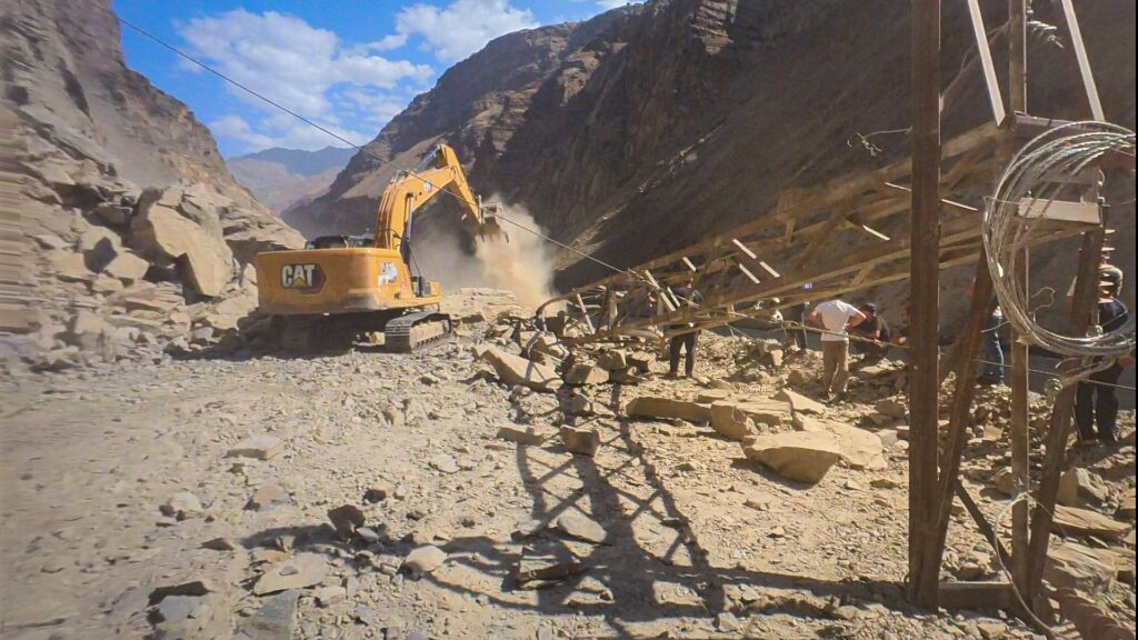 Excavator clearing a landslide on the road through the Panj gorge between Kalai Khumb and Khorugh, Tajikistan
