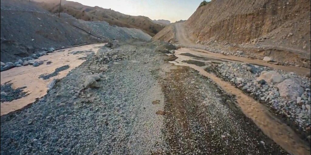 Meltwater river crossing a gravel track through a quarry on the way to the Pamir Highway