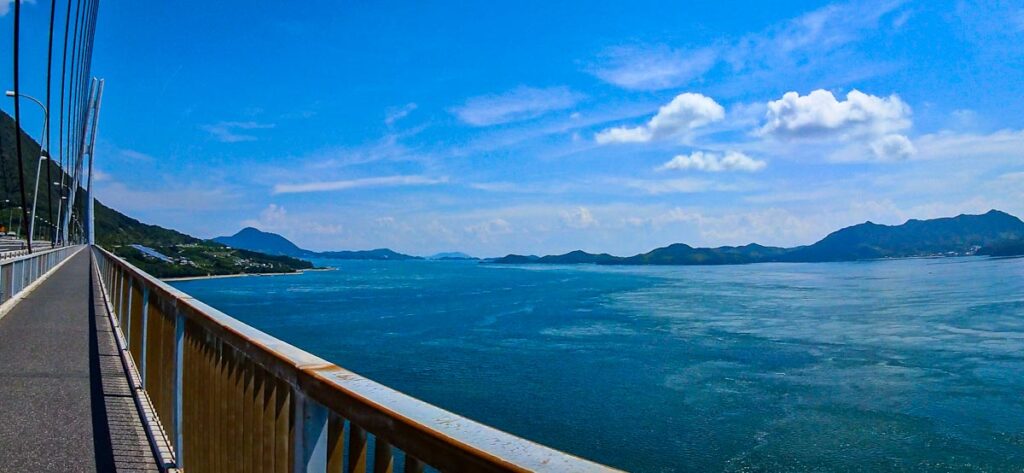 View from the cycling lane of a Shimanami Kaido bridge over the Seto Inland Sea, islands in the distance