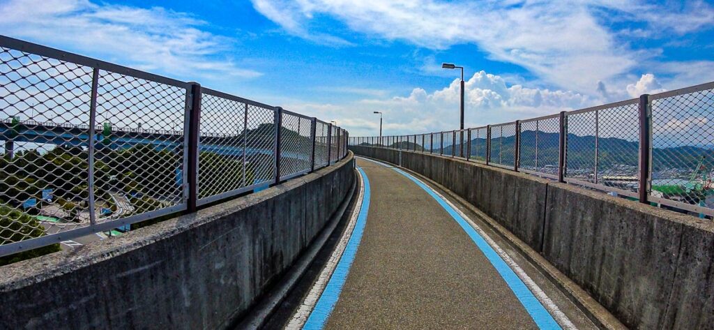Dedicated cycling path with blue line marking on a Shimanami Kaido bridge ramp