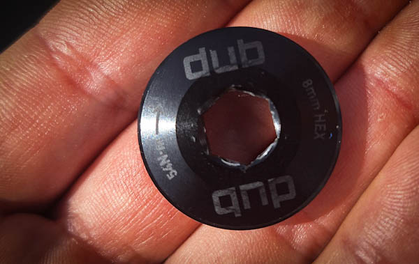 SRAM DUB Self-Extracting Cap held in hand, with 10mm hex socket